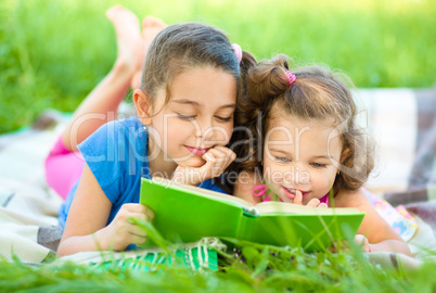 Two little girls are reading book