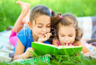 Two little girls are reading book