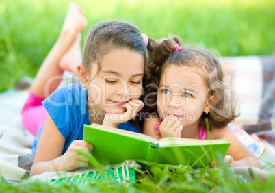 Two little girls are reading book