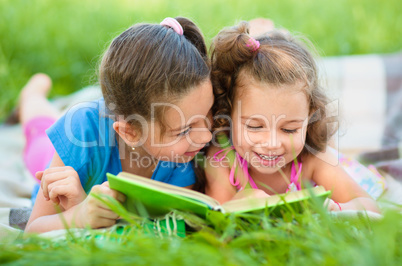 Two little girls are reading book