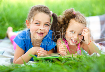 Two little girls are reading book