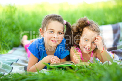 Two little girls are reading book