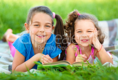 Two little girls are reading book