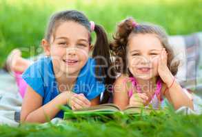 Two little girls are reading book