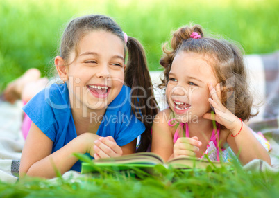 Two little girls are reading book