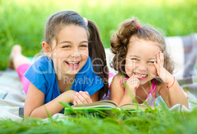 Two little girls are reading book