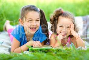 Two little girls are reading book