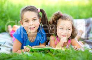 Two little girls are reading book