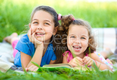 Two little girls are reading book