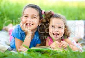 Two little girls are reading book