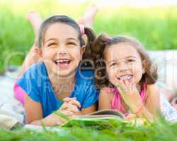 Two little girls are reading book