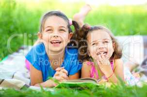 Two little girls are reading book