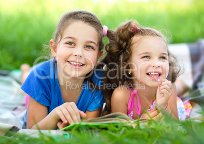 Two little girls are reading book