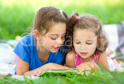 Two little girls are reading book