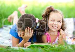 Two little girls are reading book