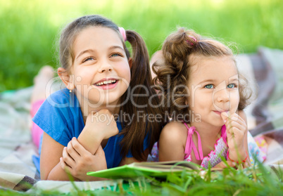 Two little girls are reading book