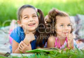 Two little girls are reading book