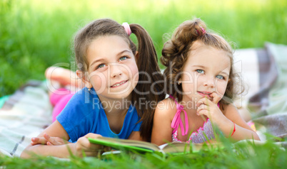 Two little girls are reading book