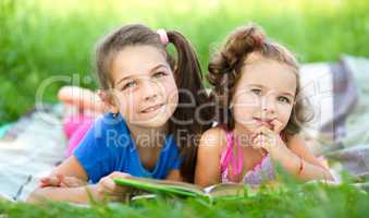 Two little girls are reading book