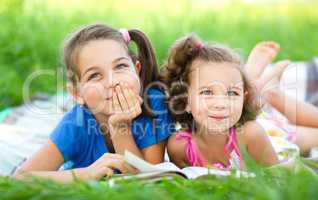 Two little girls are reading book