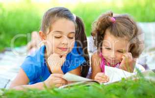 Two little girls are reading book