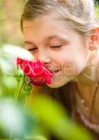Portrait of a cute little girl smelling rose