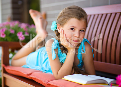 Little girl is reading a book