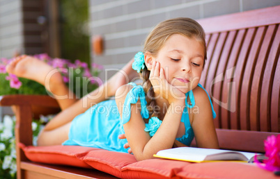 Little girl is reading a book