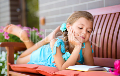 Little girl is reading a book