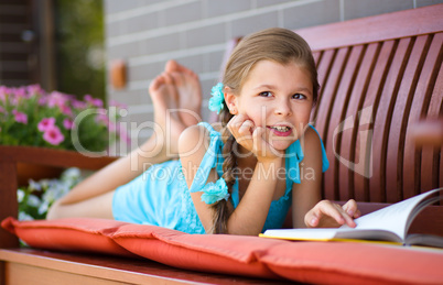 Little girl is reading a book