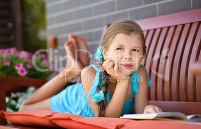 Little girl is reading a book