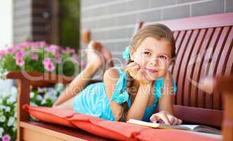 Little girl is reading a book