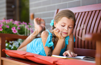 Little girl is reading a book