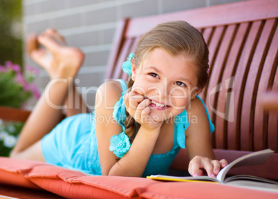 Little girl is reading a book