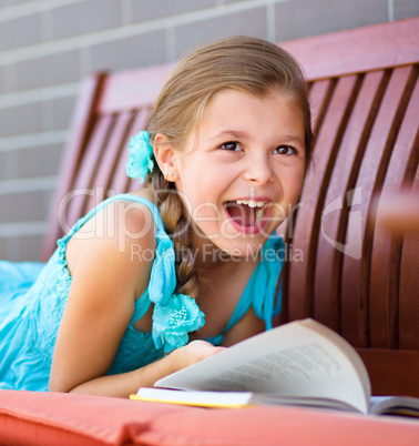 Little girl is reading a book