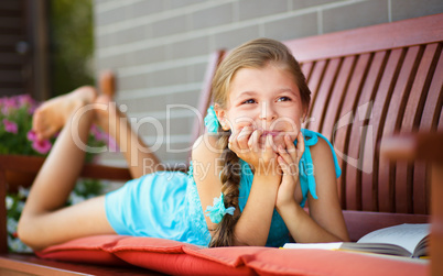 Little girl is reading a book