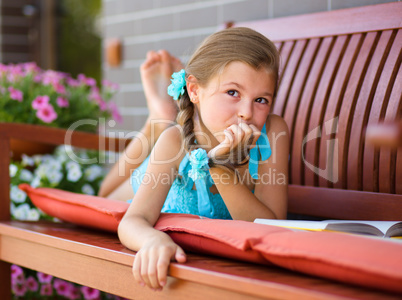 Little girl is reading a book