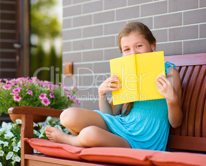 Little girl is reading a book