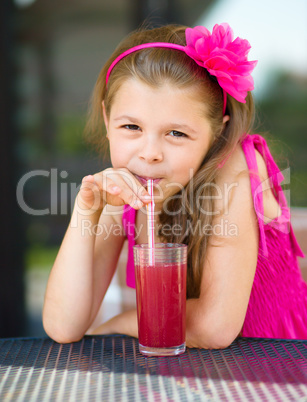 Little girl is drinking cherry juice