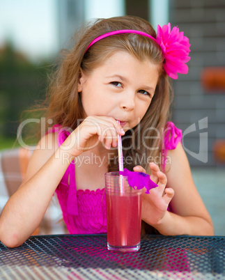 Little girl is drinking cherry juice