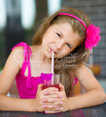 Little girl is drinking cherry juice