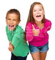 Little boy and girl are showing thumb up sign