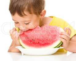 Little boy is eating watermelon
