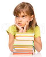 Little girl with a pile of books
