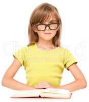 Little girl is reading a book