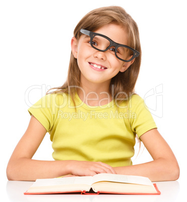 Little girl is reading a book