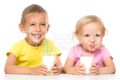 Cute little girl and boy are drinking milk