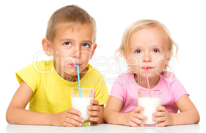 Cute little girl and boy are drinking milk