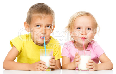 Cute little girl and boy are drinking milk