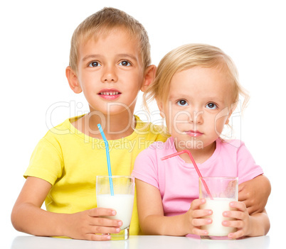 Cute little girl and boy are drinking milk